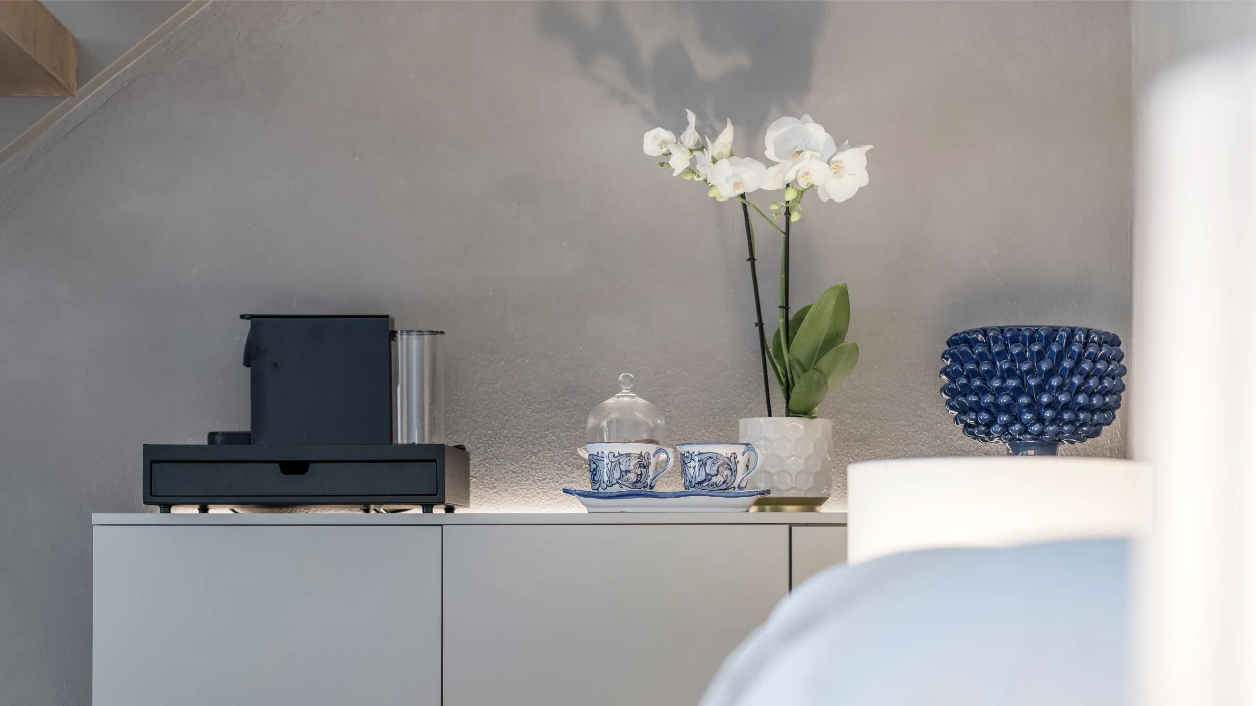 Angolo caffè camera Maupassant: tazzine in ceramica, pigna siciliana blu e macchina espresso a Villa Conrad.