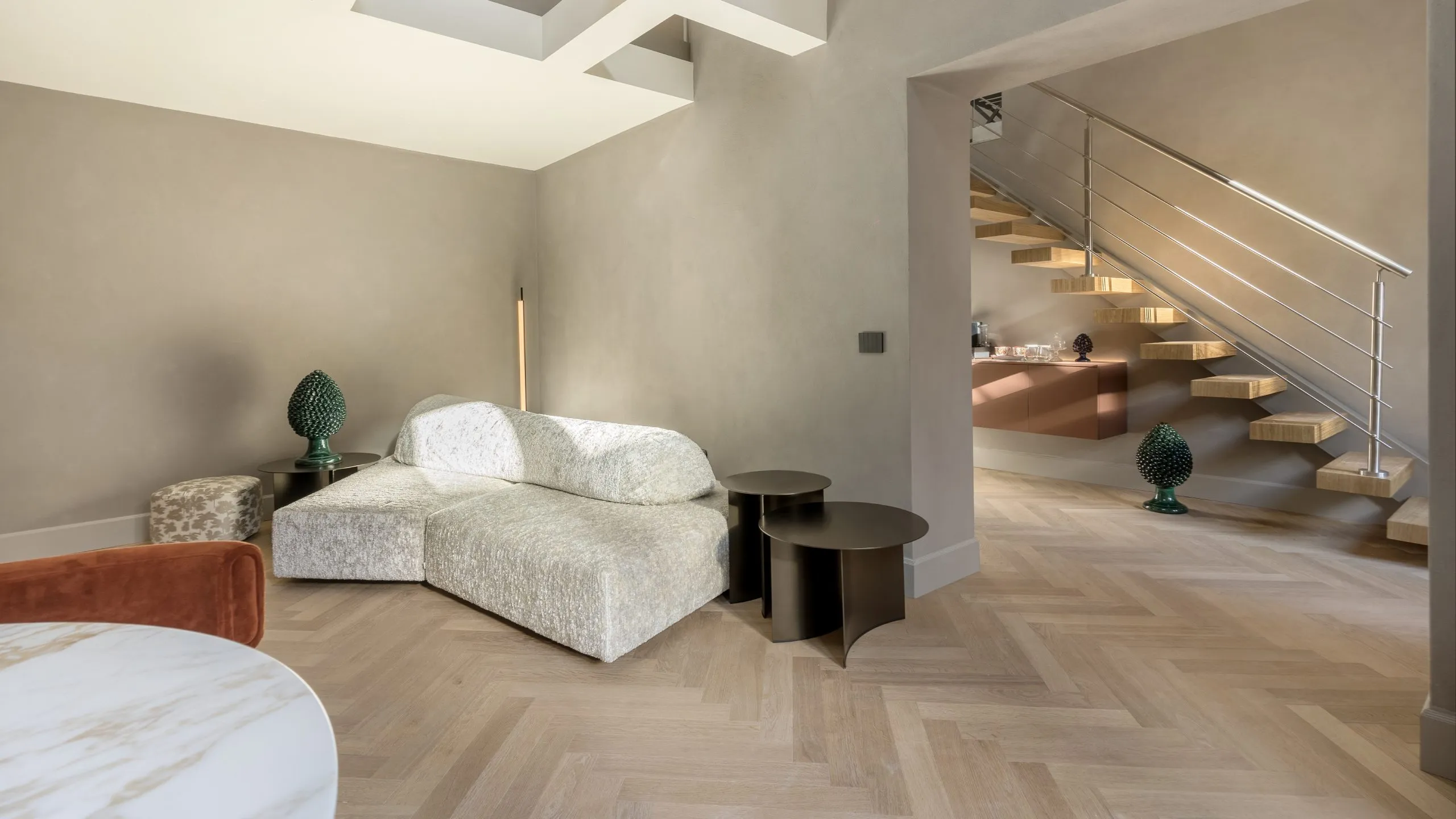 Suite su due livelli a Villa Conrad Taormina con arredi di design, scala a sbalzo e pigne in ceramica siciliana.