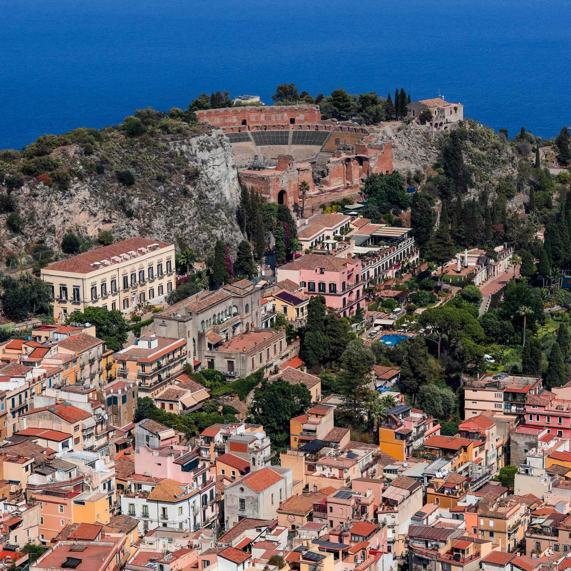 Veduta aerea di Villa Conrad a Taormina: la struttura immersa nel centro storico accanto al Teatro Antico e al mare.